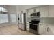 Bright kitchen featuring stainless steel appliances, white cabinets, a window, and a tiled floor at 414 Otter Creek Dr, Kissimmee, FL 34743