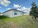 Side view of home's back exterior with a large manicured lawn and partial fence at 4373 Deleon St, Haines City, FL 33844