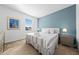Comfortable bedroom featuring a queen-size bed with a striped comforter and a bright blue accent wall at 438 Marcello Blvd, Kissimmee, FL 34746