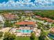 Aerial view of community clubhouse, pool, sand volleyball court, and lush landscaping at 438 Marcello Blvd, Kissimmee, FL 34746