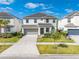 Two-story home featuring a neutral color palette, a two-car garage, and nicely landscaped front yard at 438 Marcello Blvd, Kissimmee, FL 34746