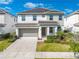 Inviting two-story home featuring a two-car garage, lush landscaping, and a welcoming front entrance at 438 Marcello Blvd, Kissimmee, FL 34746