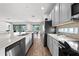 Modern kitchen with granite countertops and stainless steel appliances opens to the dining area at 438 Marcello Blvd, Kissimmee, FL 34746