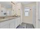 Bright bathroom features a double vanity with marble countertop and a walk-in shower with glass door at 4542 Cypress Cay Way, Kissimmee, FL 34746