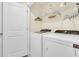 Well-equipped laundry room with side-by-side washer and dryer and wire shelving for organized storage at 4542 Cypress Cay Way, Kissimmee, FL 34746