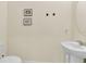 Well-lit half bath with a pedestal sink, toilet, neutral paint, and decor at 4542 Cypress Cay Way, Kissimmee, FL 34746