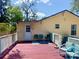 Cozy outdoor back porch with a red deck, seating, and a small outdoor table at 455 E Palmetto Ave, Longwood, FL 32750