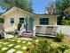 Charming home with a quaint front porch, vibrant flowers, and stepping stones leading to the entrance at 455 E Palmetto Ave, Longwood, FL 32750