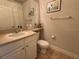 Charming bathroom featuring a toilet, sink, and framed wave art at 501 Mirasol Cir # 203, Celebration, FL 34747