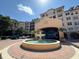 Community entrance with water fountain, circular red brick driveway, and exterior of building behind fountain at 501 Mirasol Cir # 203, Celebration, FL 34747