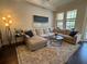 Bright and spacious living room with a comfortable sectional, modern lighting, and scenic views at 501 Mirasol Cir # 203, Celebration, FL 34747
