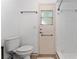 Bright bathroom with toilet, small window, and shower with white tiling at 5053 Maui Cir # 14, Orlando, FL 32808