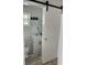 Bathroom features a sliding barn door, mirror, and vanity with neutral tones at 5562 Old Tampa Hwy, Davenport, FL 33896