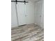 Bedroom with white walls, plank flooring, and barn door access to closet and natural light from the window at 5562 Old Tampa Hwy, Davenport, FL 33896