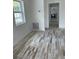 Bright living room featuring charming plank flooring, white walls and ample natural light from the window at 5562 Old Tampa Hwy, Davenport, FL 33896