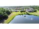 Aerial view of a home, lake, screened-in lanai and backyard featuring mature trees at 650 Portofino Drive, Poinciana, FL 34759