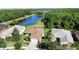 Aerial view of a single-story home featuring lush landscaping and a tranquil lake backdrop at 650 Portofino Drive, Poinciana, FL 34759