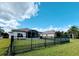 The expansive backyard features green lawn, secure black metal fencing and an inviting screened lanai at 650 Portofino Drive, Poinciana, FL 34759