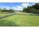 Beautiful backyard with green grass, an iron fence, and serene lake views at 650 Portofino Drive, Poinciana, FL 34759