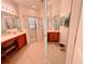 Bright bathroom featuring dual sinks, tiled floors, and a glass-enclosed shower at 650 Portofino Drive, Poinciana, FL 34759