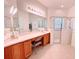 Bathroom with dual sinks, vanity area, and a glass-enclosed shower with a built-in seat at 650 Portofino Drive, Poinciana, FL 34759