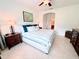 Well-lit bedroom showcases a comfortable bed, tile flooring, and a glimpse into the en-suite bathroom at 650 Portofino Drive, Poinciana, FL 34759