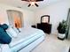 Bright bedroom with en-suite bathroom access, ceiling fan, dresser and queen bed at 650 Portofino Drive, Poinciana, FL 34759