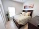 Bedroom with light neutral colors, large window and queen bed with an en-suite bathroom at 650 Portofino Drive, Poinciana, FL 34759