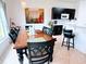 Dining room with dark wood table, six chairs, view to kitchen, and ample natural light at 650 Portofino Drive, Poinciana, FL 34759