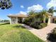 Charming single-story home featuring a well-manicured lawn and beautiful palm tree landscaping at 650 Portofino Drive, Poinciana, FL 34759