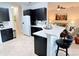 Open kitchen featuring dark cabinets, white countertops, island with seating, and stainless steel appliances at 650 Portofino Drive, Poinciana, FL 34759