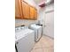 The laundry room features wooden cabinets, tiled floors, and updated washer and dryer at 650 Portofino Drive, Poinciana, FL 34759