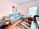 Cozy living room with blue sectional, colorful rug, and ample natural light at 650 Portofino Drive, Poinciana, FL 34759