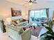 Comfortable living room with a view of the screened patio and a serene lake beyond at 650 Portofino Drive, Poinciana, FL 34759
