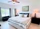 Serene main bedroom features a plush bed, decorative pillows, and abundant natural light at 650 Portofino Drive, Poinciana, FL 34759