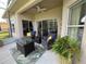 Enjoy the cozy screened patio with wicker furniture, a gas fire table, and views of the yard at 650 Portofino Drive, Poinciana, FL 34759