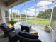 Enjoy outdoor living on the screened patio with lake views and comfortable wicker seating at 650 Portofino Drive, Poinciana, FL 34759