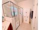 Shower with glass door, linen cabinet, and white neutral colors at 650 Portofino Drive, Poinciana, FL 34759