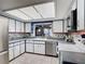 Bright kitchen featuring white and blue cabinetry, stainless steel appliances, and ceramic tile flooring at 724 Knob Hill Cir, Kissimmee, FL 34744