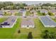 Beautiful aerial view of homes with solar panels and lush green lawns near the water at 724 Lake Cummings Blvd, Lake Alfred, FL 33850