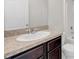 Bathroom vanity features dark wood cabinets, granite countertops, white sink, faucet, mirror and toilet at 724 Lake Cummings Blvd, Lake Alfred, FL 33850