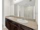 Spacious bathroom with double sink vanity, large mirror, granite countertops, and dark wood cabinets at 724 Lake Cummings Blvd, Lake Alfred, FL 33850