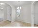Bright dining room featuring tile floors, a chandelier, and a window providing natural light at 724 Lake Cummings Blvd, Lake Alfred, FL 33850