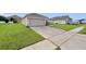 Single-story home featuring an attached two-car garage and large driveway at 724 Lake Cummings Blvd, Lake Alfred, FL 33850