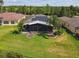 Aerial view of home featuring a screened lanai, solar panels, and a well-manicured lawn at 759 Glendora Rd, Poinciana, FL 34759