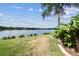 Beautiful waterfront backyard with tropical landscaping and lake view, ideal for relaxation at 759 Glendora Rd, Poinciana, FL 34759