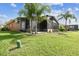 Lush backyard with green lawn and screened lanai offers the perfect outdoor space for relaxation at 759 Glendora Rd, Poinciana, FL 34759
