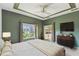 The main bedroom is painted in an olive tone with a ceiling fan, dresser, and access to the lanai at 759 Glendora Rd, Poinciana, FL 34759