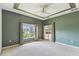 Spacious carpeted main bedroom with a trey ceiling, ceiling fan, a large window and access to the lanai at 759 Glendora Rd, Poinciana, FL 34759