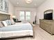 Bright bedroom with a large bed, dresser, and two windows, offering a peaceful retreat at 932 Wild Date Ln, Lake Mary, FL 32746